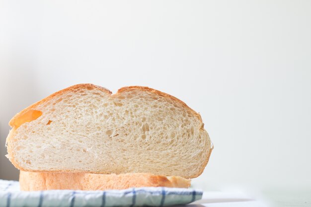 Fresh home made bread on white table background with napkin.