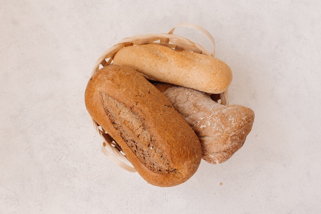 Fresh homemade baked bread and sliced bread with milk on rustic white wooden table