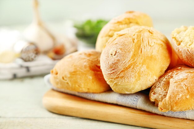 Fresh homemade bread buns from yeast dough on wooden tray on color wooden background