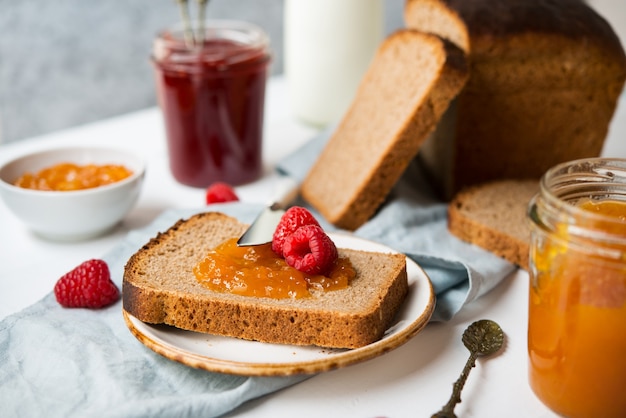 Fresh homemade bread with jam and milk, homemade simple food, light background