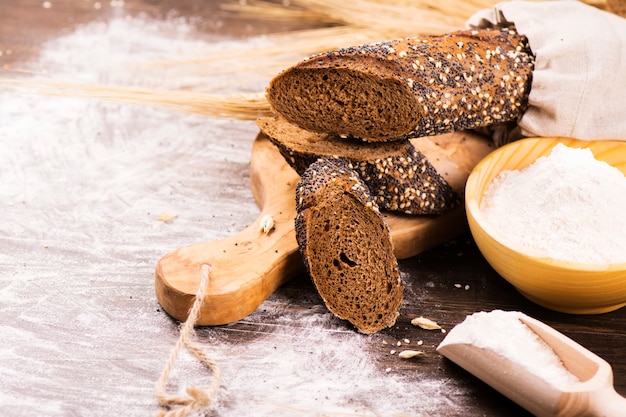 Fresh homemade bread with sesame and poppyseed on wooden table.