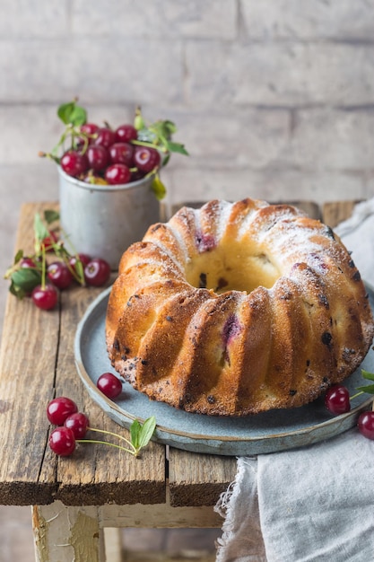 Ciambella fresca fatta in casa con ciliegia su tavola di legno