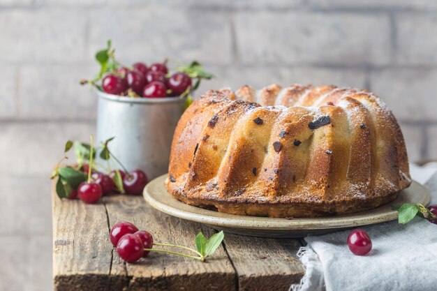 Fresh homemade bundt cake with cherry on wooden table