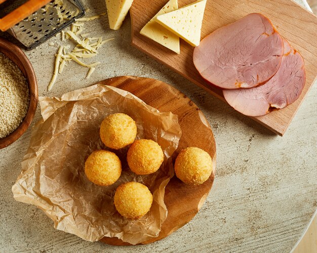 Fresh homemade cheese balls on wooden cutting board