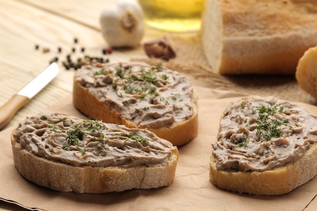 Paté di fegato di pollo fresco fatto in casa con erbe per pane su un tavolo di legno naturale. un panino.