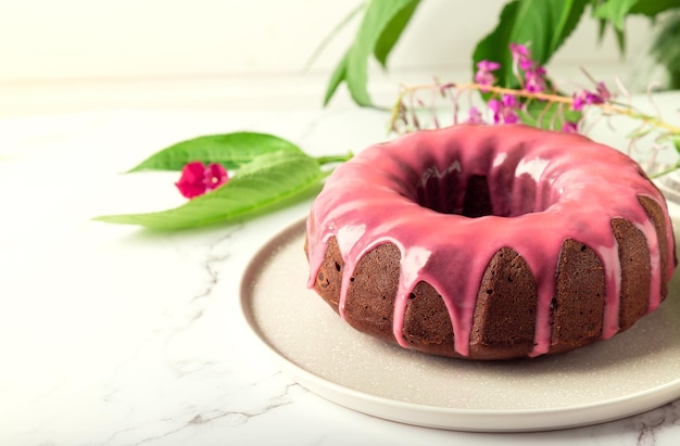 Photo fresh homemade chocolate bundt cake decorated with pink glaze