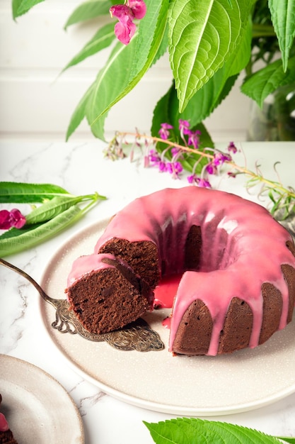 Ciambellone al cioccolato fresco fatto in casa decorato con glassa rosa