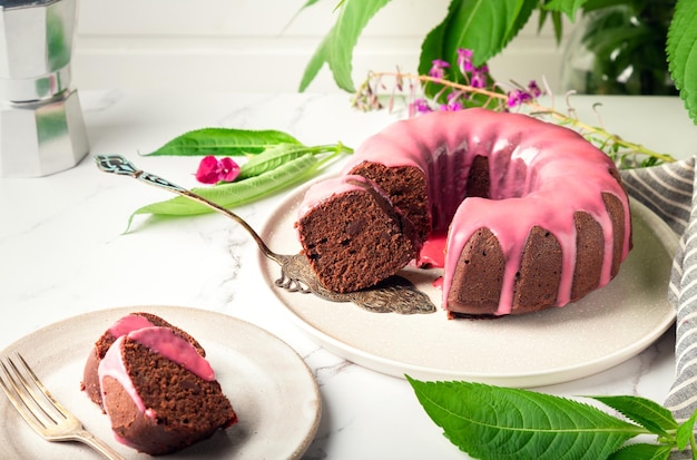 Fresh homemade chocolate bundt cake decorated with pink glaze