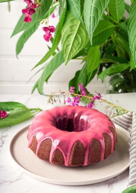 Fresh homemade chocolate bundt cake decorated with pink glaze