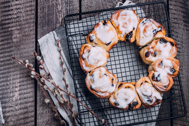 Свежие домодельные крены cinnabon на таблице. Пасхальная выпечка на праздник. Вертикальный вид сверху копией пространства