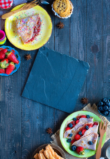 Fresh homemade crepes served on a plate with strawberries and blueberries