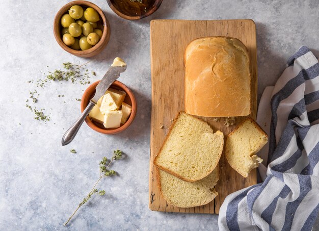 신선한 홈 메이드 바삭 바삭한 빵과 올리브 오일, 버터, 그린 올리브, 평면도와 조각. 빵 굽기