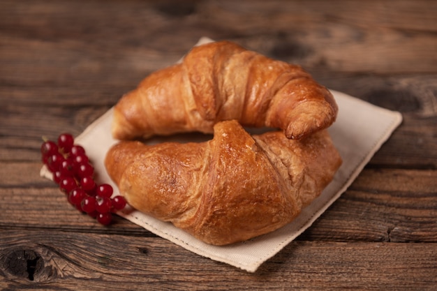 Fresh homemade croissants on wooden table close up