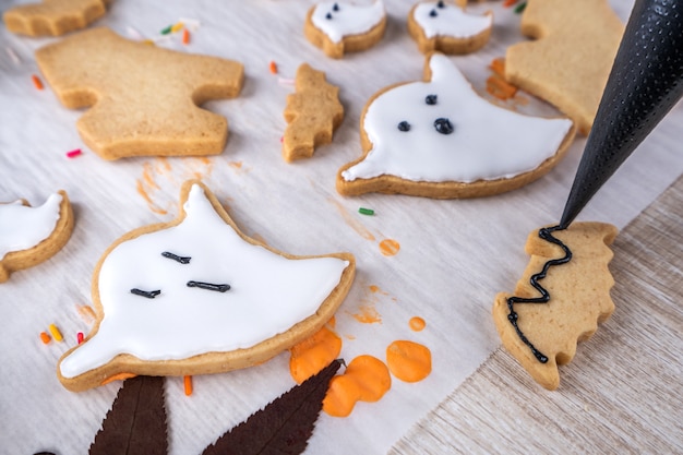 Fresh homemade decorating halloween dessert with ghost, creeping spider, bat, haunted castle and horrifying eyeball on wooden background, copy space