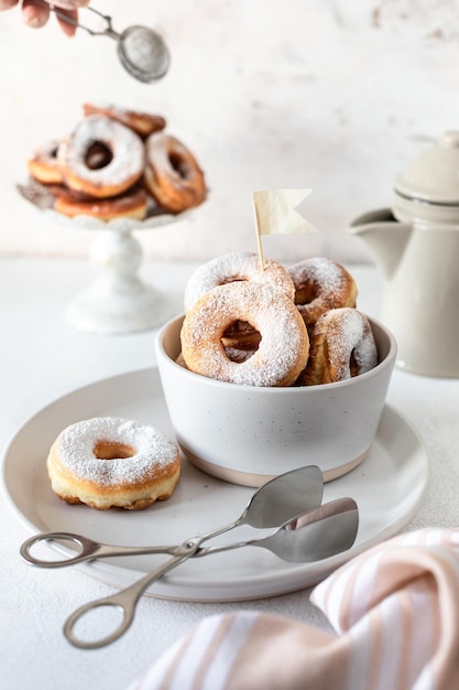 Fresh homemade fried donuts covered with powdered sugar on a white background Selective focus