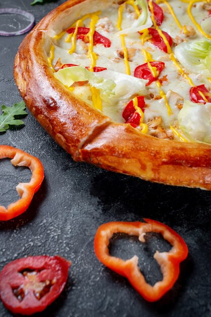 어두운 배경에 올리브와 붉은 불가리아 고추를 곁들인 신선한 홈메이드 이탈리아 피자 마르게리타