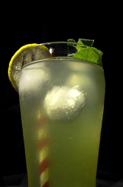 Fresh Homemade Lemonade or mojito cocktail with lemon mint and ice on dark bacground