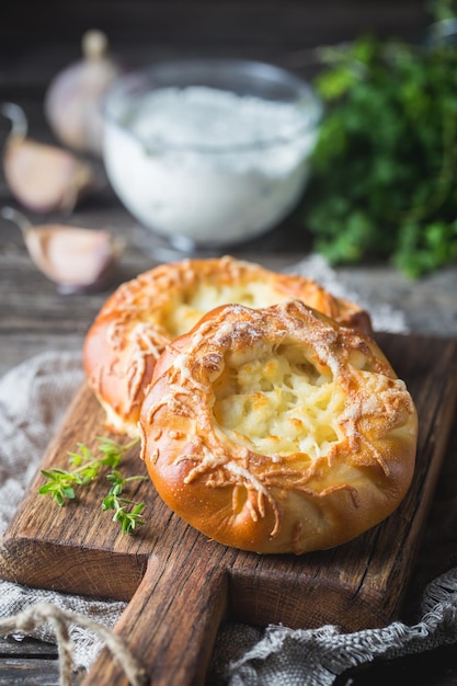 Fresh homemade open patties with cheese. Traditional Russian yeast pastry, round buns, curd tart. Buns with cottage cheese. Rustic style.