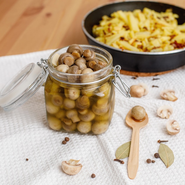 Photo fresh homemade pickled champignon mushrooms in glass jar on table