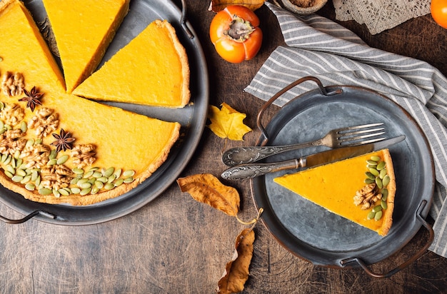Fresh homemade pumpkin pie for Thanksgiving decorated with walnuts and seeds