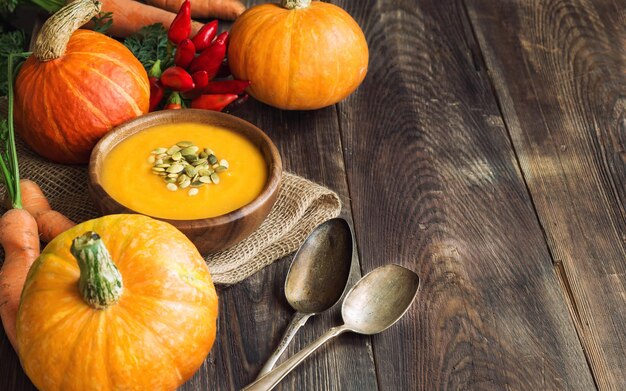 Foto suppa di zucca fresca fatta in casa con ingredienti su sfondo rustico in legno area di copia dello spazio