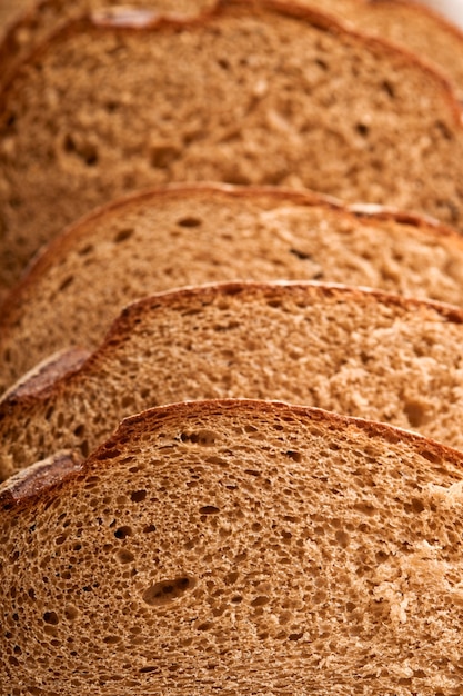 Fresh homemade rye bread. Traditional spelled sourdough bread cut into slices on a rustic wooden background. Concept of traditional leavened bread baking methods. Selective focus.