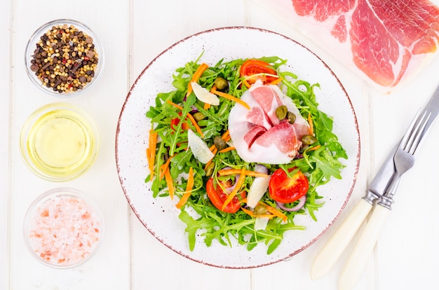 Arugula, jamon, rucola, 토마토, 치즈와 신선한 홈 메이드 샐러드.