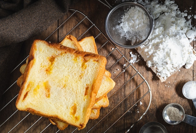 Pane affettato casalingo fresco impilato sul fondo scuro di struttura della tavola di legno