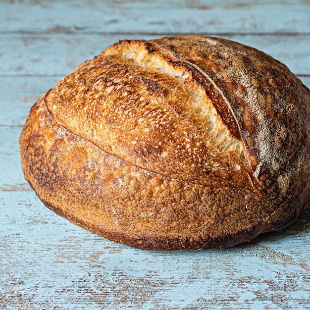 Fresh homemade sourdough bread with whole grain flour on a gray-blue background. Healthy food.