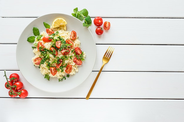 Fresh homemade tabouli or tabbouleh salad top view on white wooden background with copy space