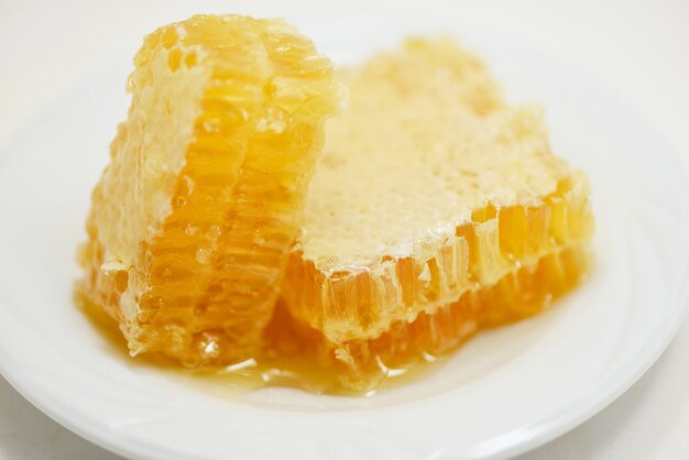 Fresh honey / Close up of yellow sweet honeycomb slice on plate natural healthy food 