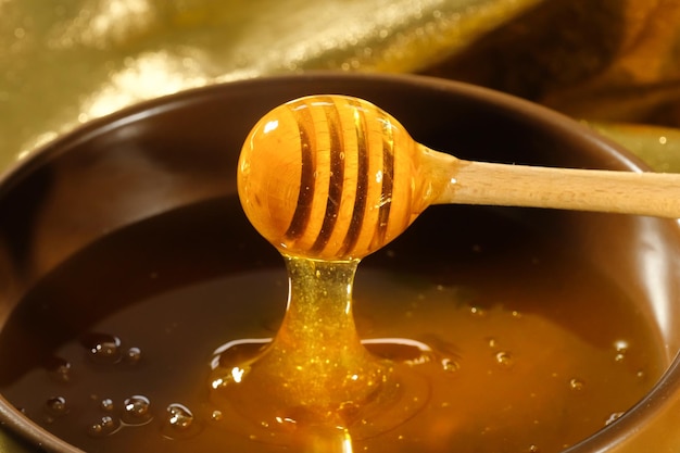 Fresh honey dripping from a ladle into a plate organic natural bee products