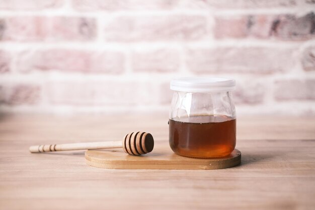 Fresh honey in a glass jar on table with copy space