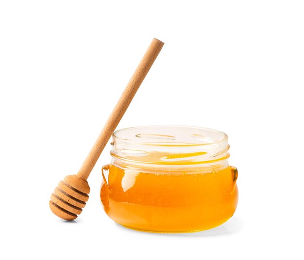 Fresh honey in a jar with a wooden dipper on a white isolated background