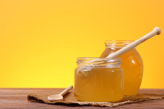 Fresh honey on the table closeup on a colored background