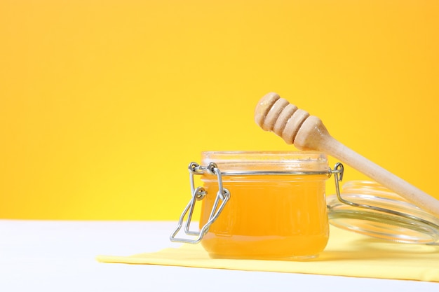 Fresh honey on the table closeup on a colored background