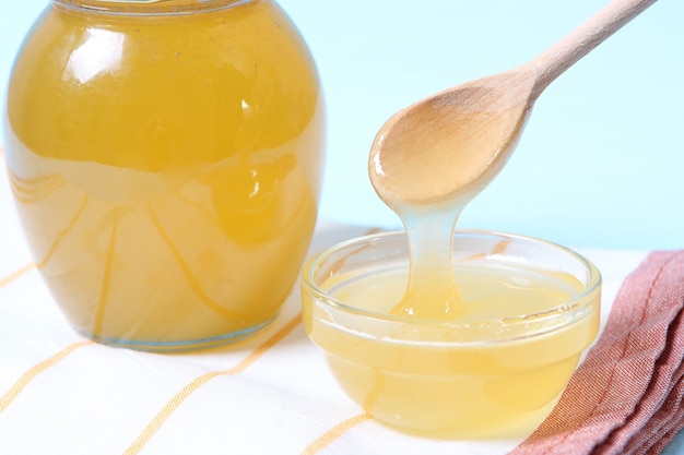 Fresh honey on the table closeup on a colored background