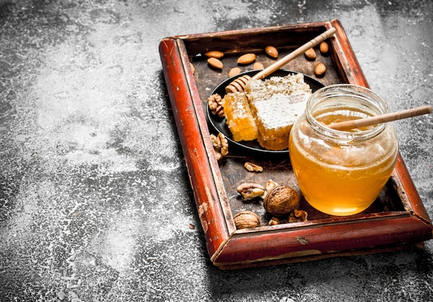 Miele fresco con noci. sulla tavola rustica.