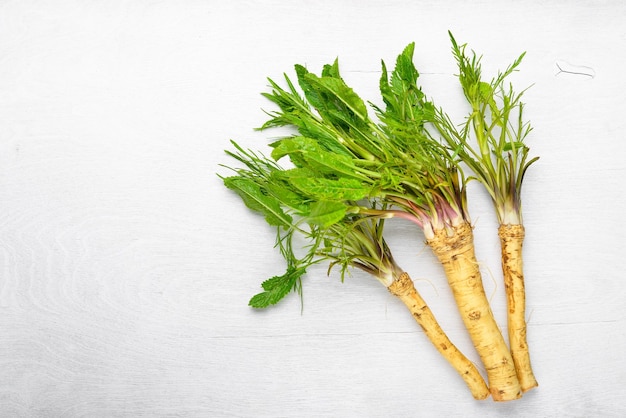 Fresh horseradish The white Wooden desk Top view