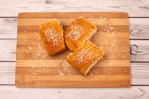 Fresh hot buns with seeds on wooden desk