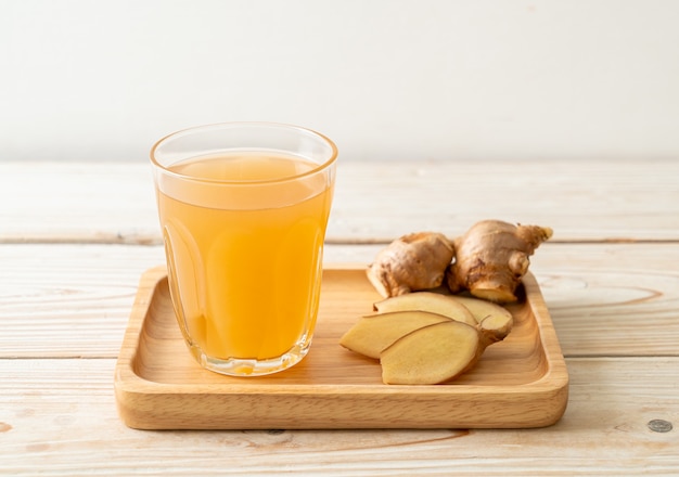 Photo fresh and hot ginger juice glass with ginger roots - healthy drink style