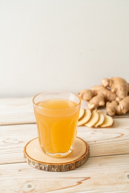 生姜の根を持つ新鮮で熱い生姜ジュースグラス-健康的な飲み物のスタイル