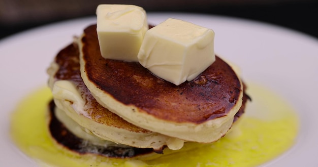 Foto pancake freschi e caldi con burro in un piatto vicino