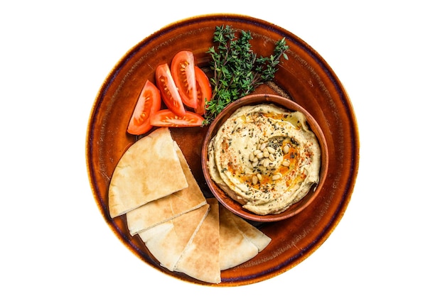 Hummus fresco con pane pita pomodoro e prezzemolo su un piatto rustico isolato su sfondo bianco