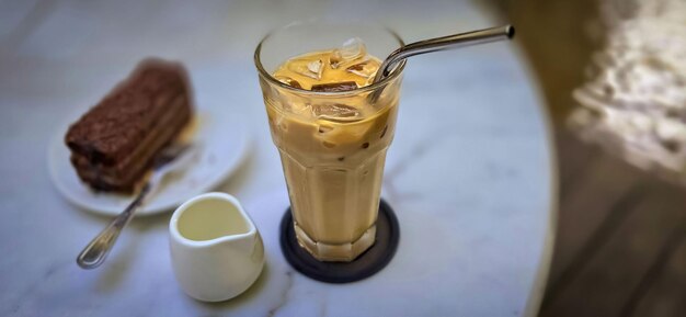 Photo fresh iced coffee in glass with frothy cream for your design food concept in style copy space