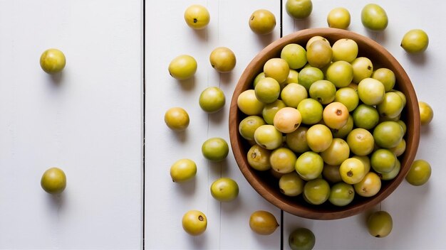 Fresh indian gooseberry fruits in wooden bowl on white