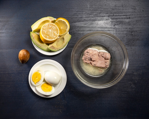 Fresh ingredients for homemade guacamole on a wooden table