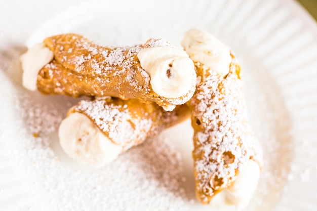 Fresh Italian cannoli with coffee on the table.