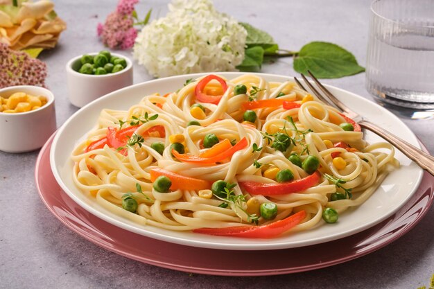 Fresh Italian pasta with green peas bell peppers and corn Closeup Italian Cuisine