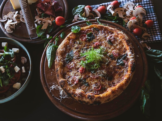 A fresh italian pizza and vegetables on the table